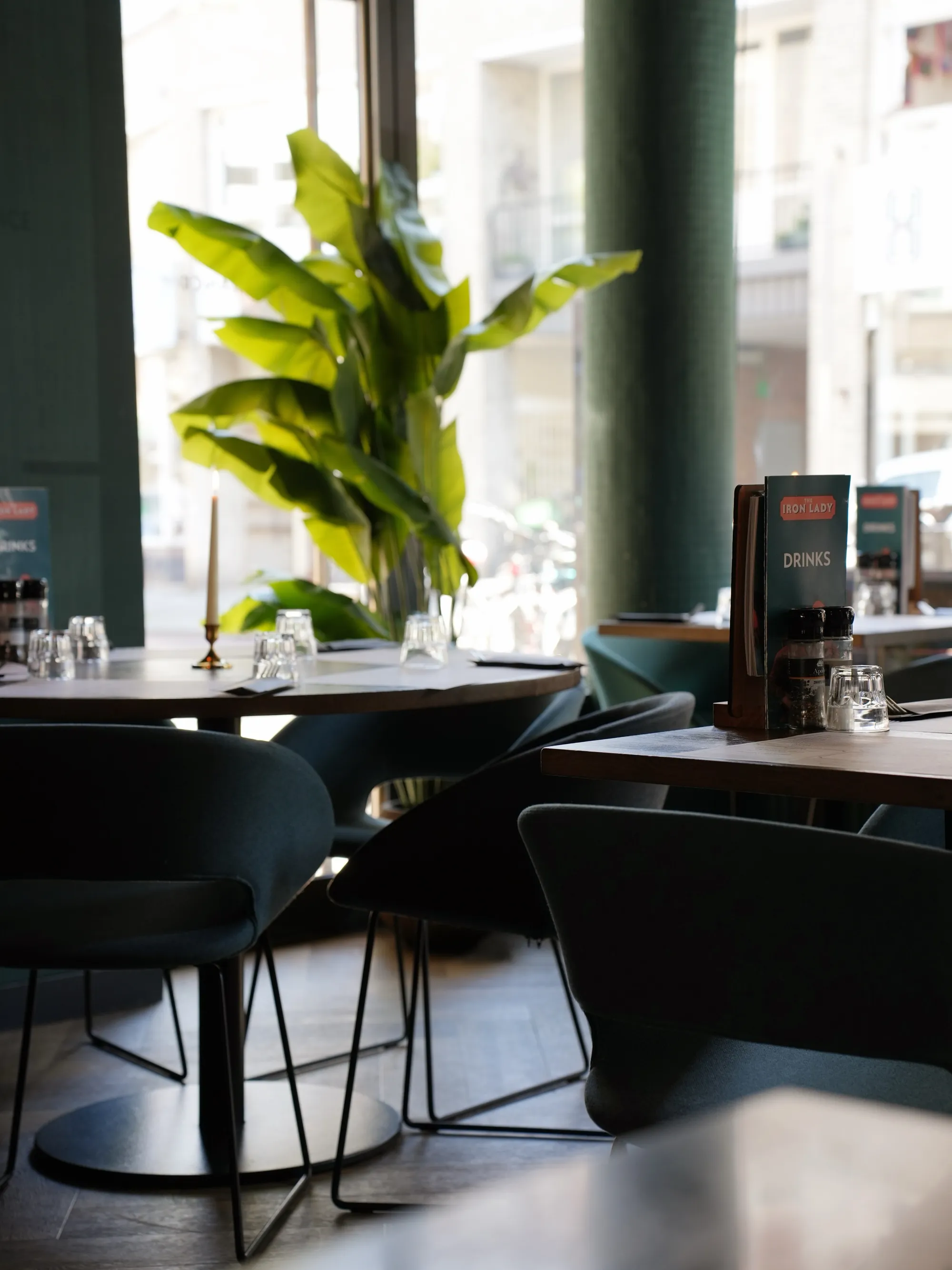 The daylight dining room at The Iron Lady, tables set by the window
